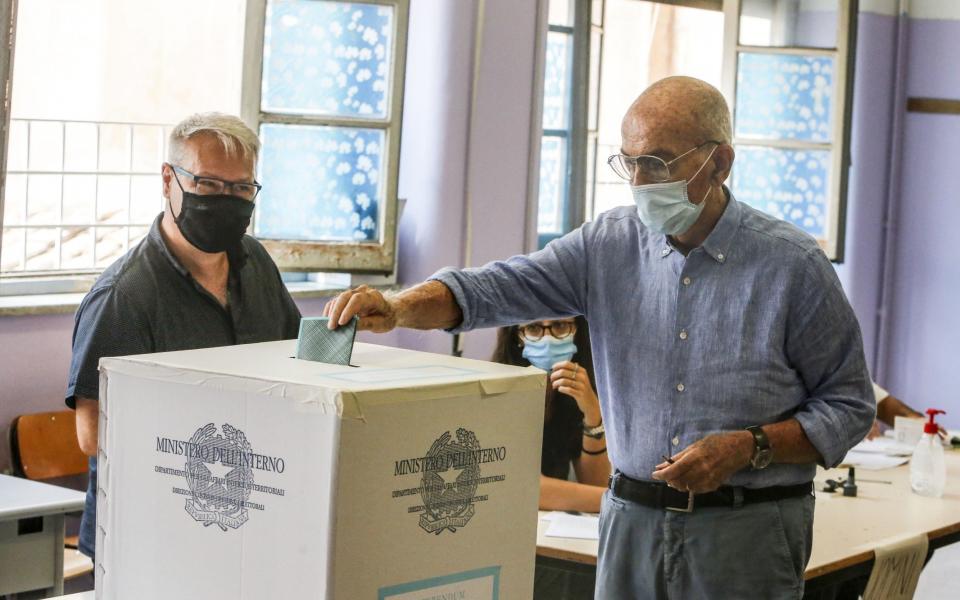 A voter wearing a protective face mask casts his ballot for the constitutional referendum on the reduction of lawmakers - Anadolu