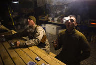 <p>U.S. Marines from MP Company, 1st Marine Division attached to 3rd Battalion 4th Marines, smoke cigars as they play cards at AHP station in Nimroz province, southern Afghanistan, on Jan. 14, 2010. (Photo: Marko Djurica/Reuters) </p>