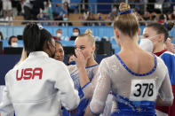 Simone Biles, of the United States, congratulates gymnasts from the Russian Olympic Committee's Liliia Akhaimova, back to camera, Vladislava Urazova, right, and Angelina Melnikova after they won the gold medal at the 2020 Summer Olympics, Tuesday, July 27, 2021, in Tokyo. (AP Photo/Ashley Landis)