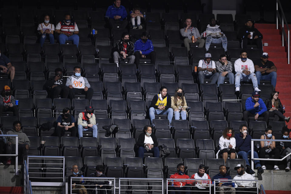 Basketball fans watch during the first half of an NBA basketball game between the Washington Wizards and the Golden State Warriors, Wednesday, April 21, 2021, in Washington. (AP Photo/Nick Wass)