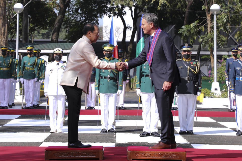 In this photo provided by the Department of National Defense, Defense Communications Service, Philippines Defense Chief Carlito Galvez Jr., left, shakes hands with Australian Deputy Prime Minister and Defense Minister Richard Marles during his visit at Camp Aguinaldo in Quezon City, Philippines on Wednesday Feb. 22, 2023. (Department of National Defense, Defense Communications Service via AP)