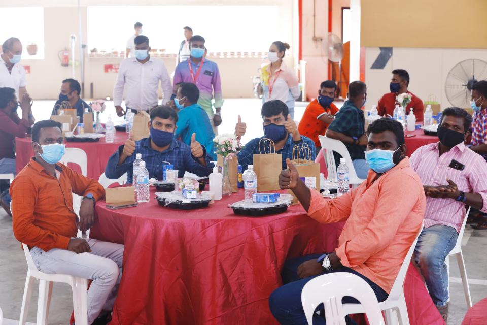 Migrant workers receiving Deepavali treats from community groups in Singapore.