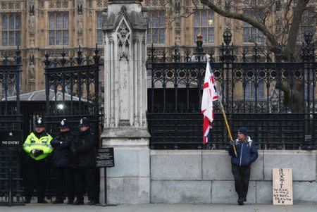 A pro-Brexit protester holds flags as he stands outside the Houses of Parliament in London, Britain, January 21, 2019. REUTERS/Hannah McKay