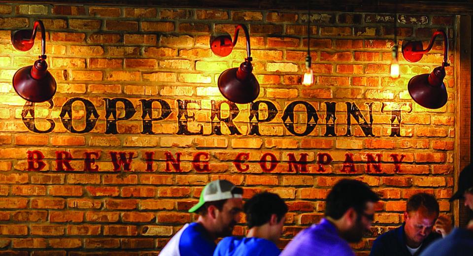 The Copperpoint Brewing Company logo is prominently displayed on the brick wall in the Copperpoint craft beer brewery in Boynton Beach, FL.