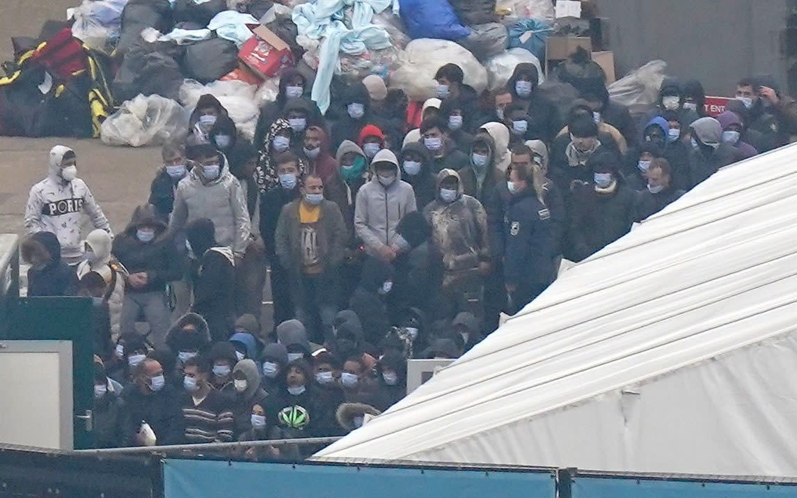 A group of migrants wait to be processed after being brought into Dover, Kent, on Monday. Rishi Sunak says he wants to lower migration but must deal with Channel crossings first - Gareth Fuller/PA