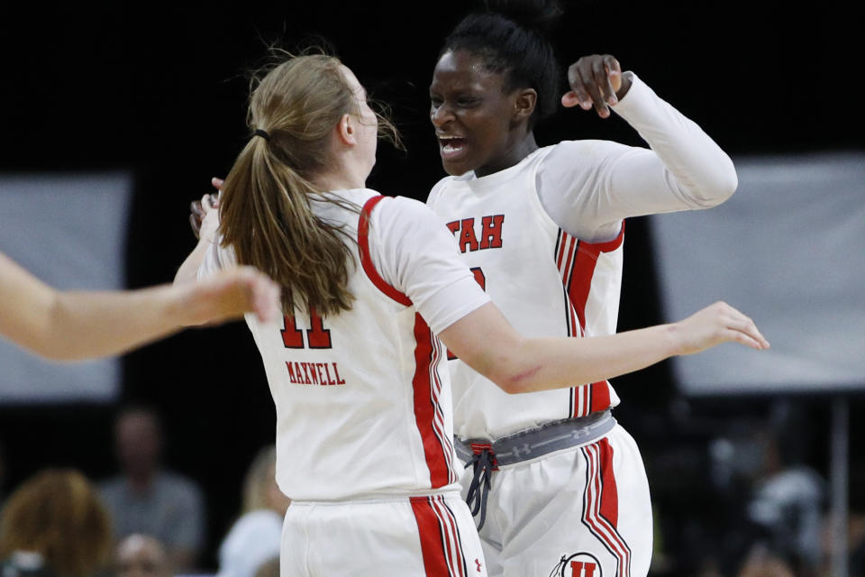 Utah's Brynna Maxwell, left, celebrates with Lola Pendande during the second half of an NCAA college basketball game against Washington in the first round of the Pac-12 women's tournament Thursday, March 5, 2020, in Las Vegas. (AP Photo/John Locher)