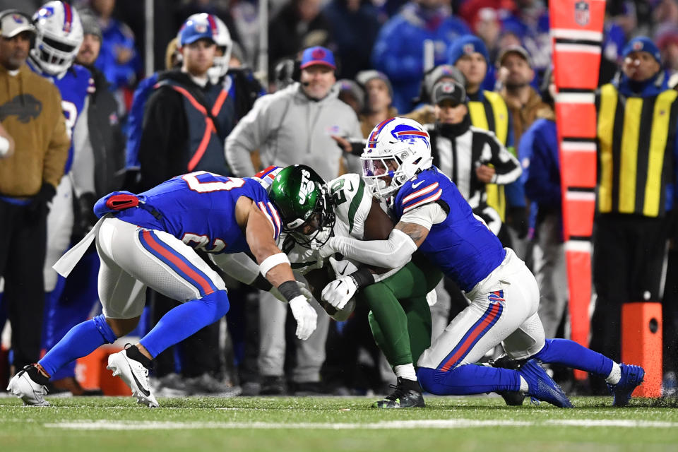 New York Jets running back Breece Hall, center, is tackled by Buffalo Bills safety Taylor Rapp (20) and Taron Johnson (7) during the first half of an NFL football game in Orchard Park, N.Y., Sunday, Nov. 19, 2023. Rapp was injured on the play and was taken off the field in an ambulance. (AP Photo/Adrian Kraus)