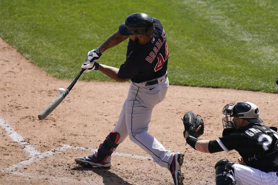 Cleveland Indians' Bobby Bradley breaks his bat on a swing, next to Chicago White Sox catcher Yasmani Grandal during the third inning of a spring training baseball game Saturday, March 20, 2021, in Phoenix. (AP Photo/Ross D. Franklin)