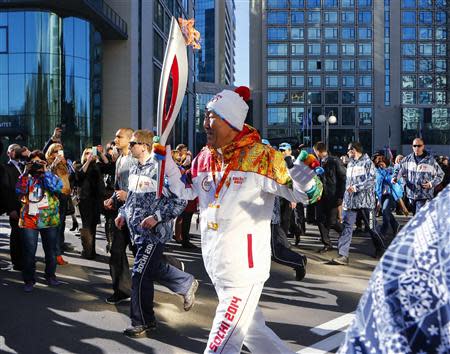 United Nations Secretary-General Ban Ki-moon runs with the 2014 Sochi Olympics torch as the torch relay arrives in Sochi February 6, 2014. REUTERS/Shamil Zhumatov