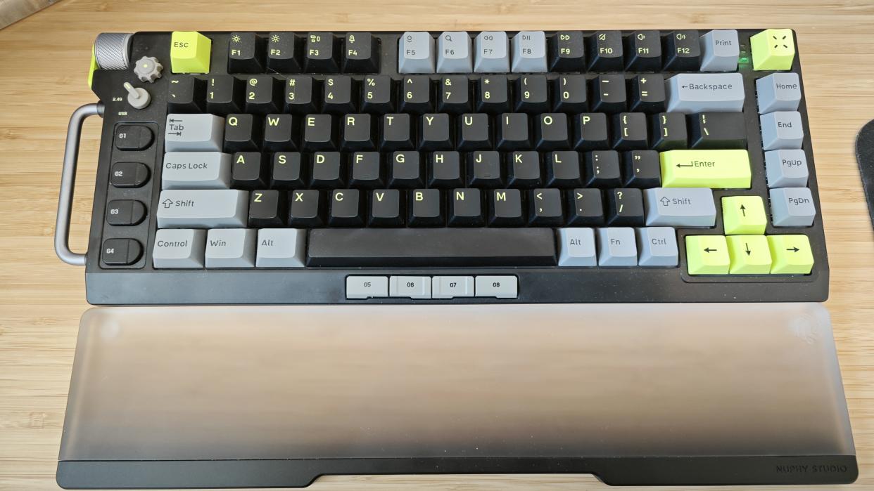  A black and green NuPhy Field75 keyboard on a wooden desk 