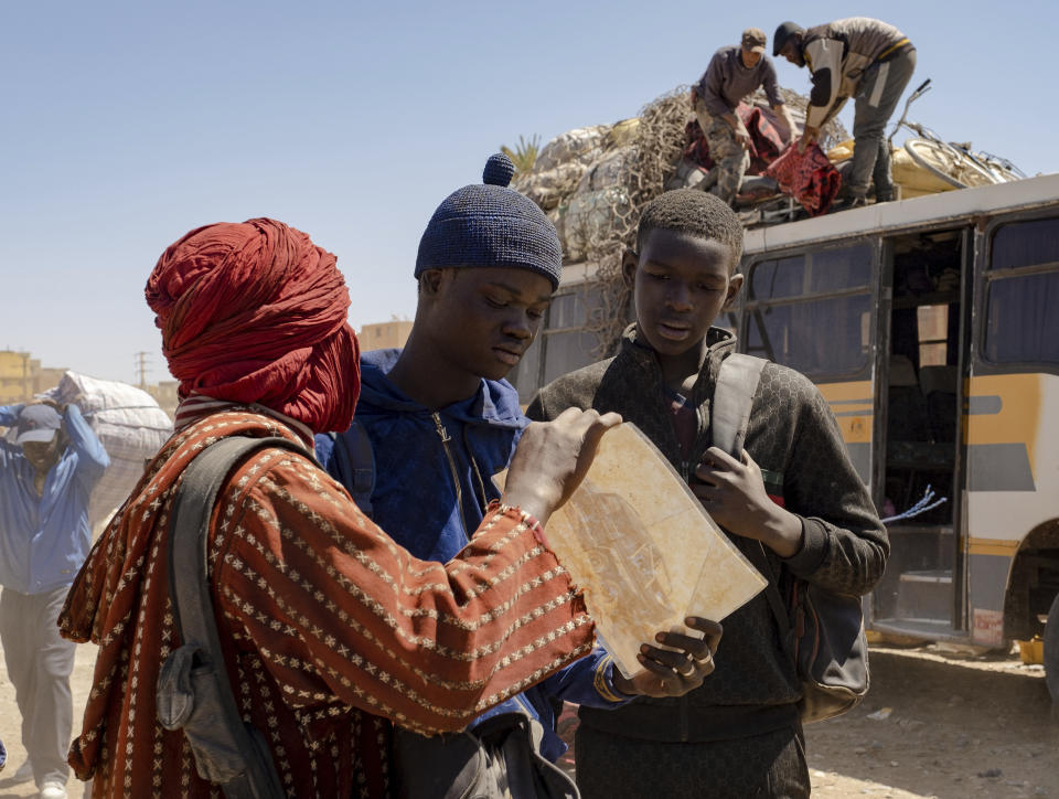 En esta fotografía del 29 de marzo de 2022 proporcionada por 01 Distribuzione, los actores senegaleses Moustapha Fall, centro, y Seydou Sarr, derecha, en el set de la película del director italiano Matteo Garrone "Io Capitano" ("Yo capitán") en el mercado de Rissani, en Marruecos. La película nominada en la 96a entrega de los Premios de la Academia en la categoría de largometraje internacional está inspirada en la travesía de Mamadou Kouassi, un migrante que hizo el viaje desde su natal Costa de Marfil a Italia. (Greta De Lazzaris/01 Distribuzione vía AP, HO)