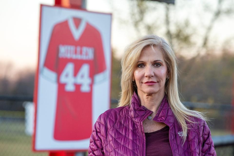 Regina Mullen, mother of Kyle Mullen, who died following Navy SEAL training last year, stands in front of the scoreboard on the football field, where an image of her son's jersey hangs, at Manalapan High School in Manalapan, NJ Monday, January 30, 2023. 