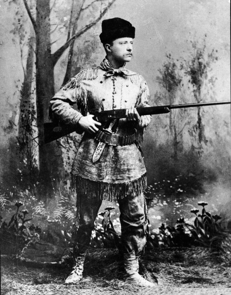 A full-length studio portrait of Theodore Roosevelt (1858 - 1919), president of the United States from 1901 to 1909, wearing hunting gear and holding a Winchester gun in an artificial forest setting, circa 1900.<span class="copyright">Pictorial Parade/Getty Images</span>