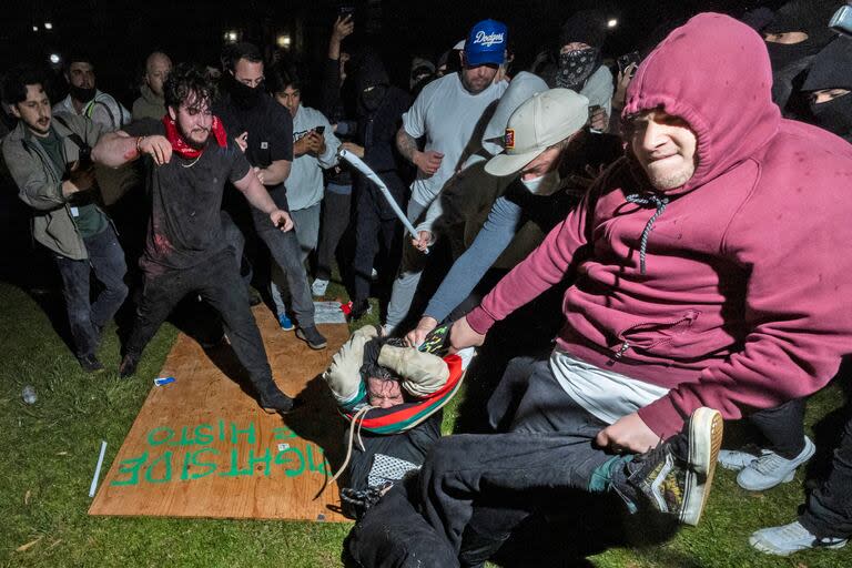 Un manifestante pro palestino es golpeado por contramanifestantes que atacan un campamento pro palestino establecido en el campus de la Universidad de California en Los Ángeles (UCLA) mientras estallan los enfrentamientos, en Los Ángeles el 1 de mayo de 2024