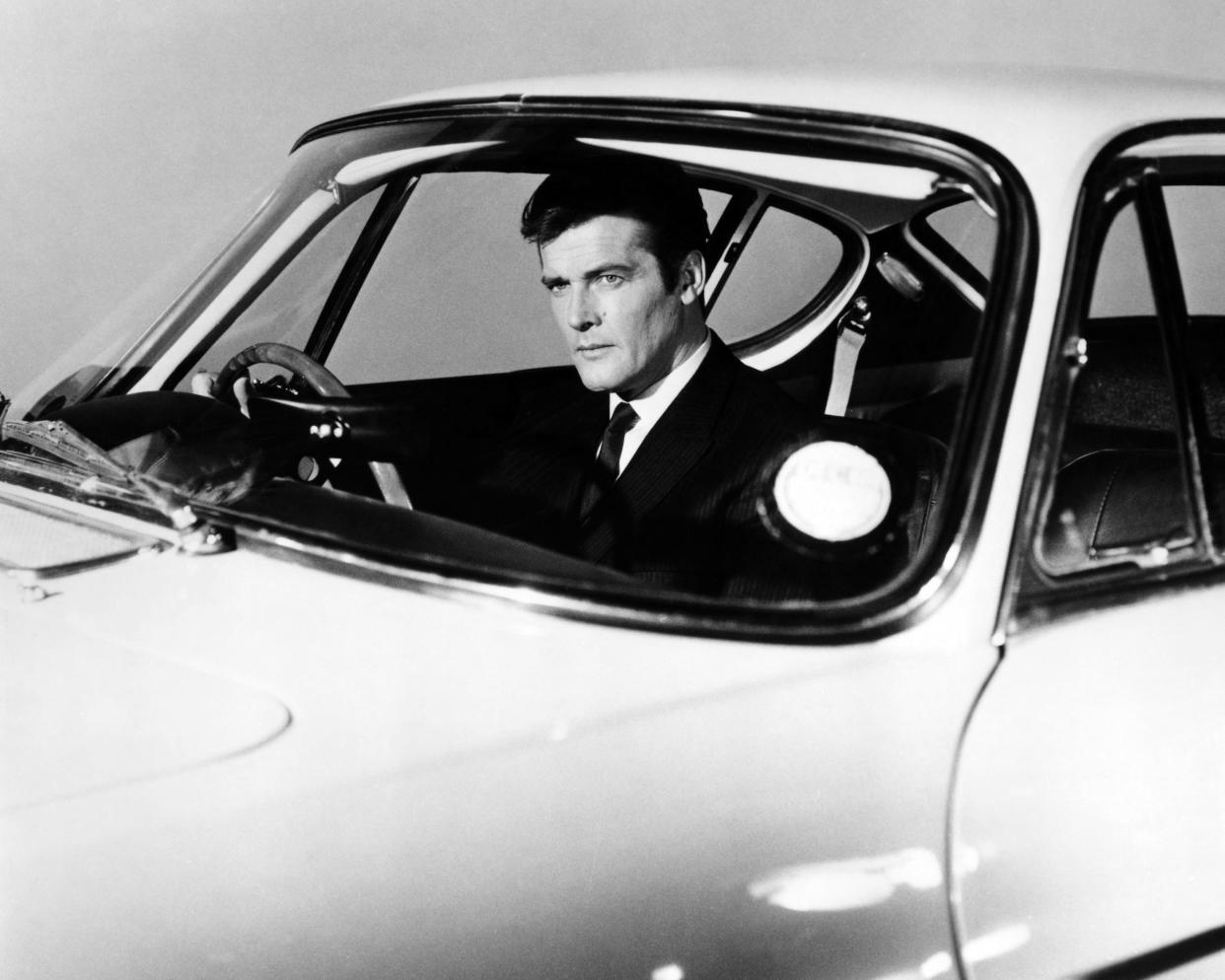 English actor Roger Moore as Simon Templar, in a promotional portrait at the wheel of a Volvo P1800 sports car, for the British spy thriller TV series 'The Saint', circa 1965. (Photo by Silver Screen Collection/Getty Images)