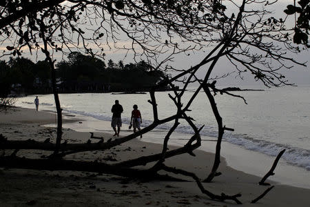 FILE PHOTO: People walk along the beach in Seychelles February 29, 2012. REUTERS/Ahmed Jadallah/File Photo