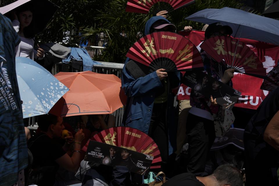 In this May 16, 2023 photo, fans wait in line to see actors arriving at the premiere of the film 'Only the River Flows' during the 76th international film festival in Cannes, southern France. (AP Photo/Daniel Cole)