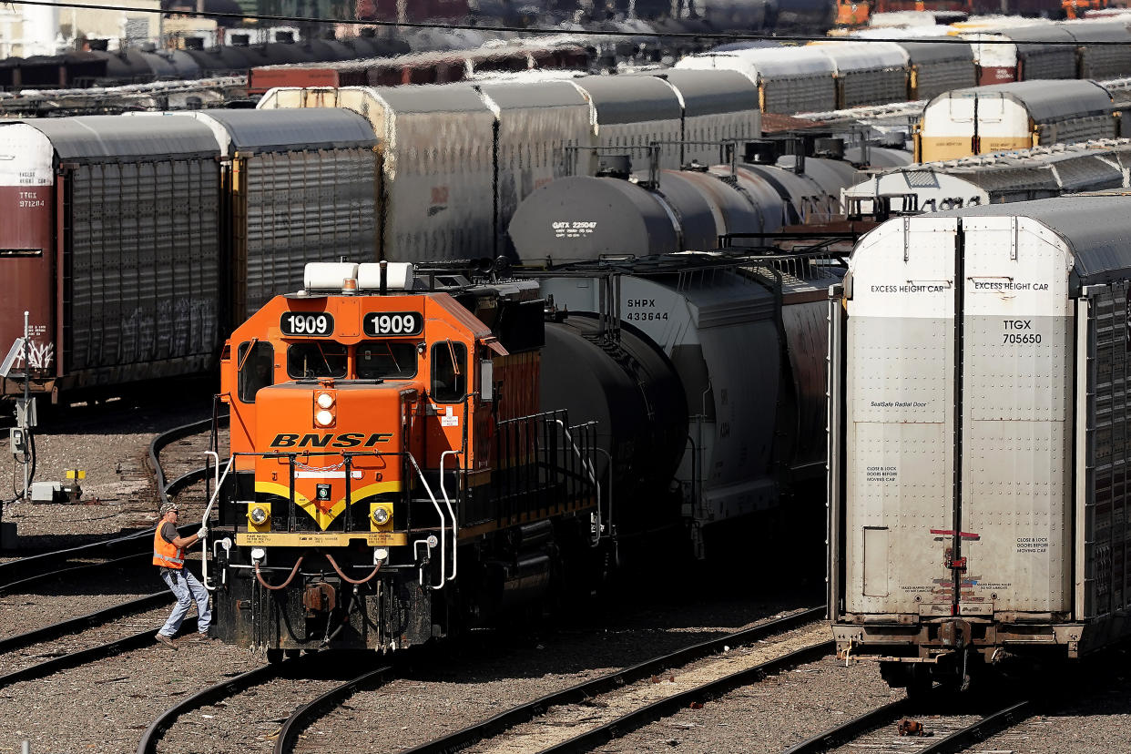 A worker boards a locomotive at a BNSF rail yard on Sept. 14, 2022, in Kansas City, Kan. (Charlie Riedel/AP)