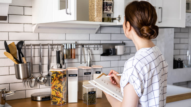 woman in kitchen with notebook