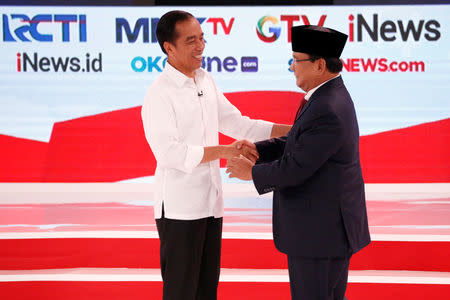 Indonesia's presidential candidate Joko Widodo (L) shakes hands with his opponent Prabowo Subianto after the second debate between presidential candidates ahead of the next general election in Jakarta, Indonesia, February 17, 2019. REUTERS/Willy Kurniawan