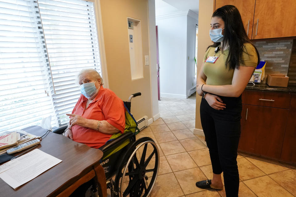 Project Hope Crisis Counselor Danielle Iorlano, right, talks to Arlene Rappaport and other members of her family during the observation period after Arlene was inoculated against the coronavirus in her home in Levittown, N.Y., Thursday, May 20, 2021. Once a week Mount Sinai South Nassau's Vaxmobile staff visit homebound residents to administer the Johnson & Johnson COVID-19 vaccine. (AP Photo/Mary Altaffer)