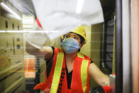 A contractor cleans a subway car at the 96th Street station to control the spread of COVID-19, Thursday, July 2, 2020, in New York. Mass transit systems around the world have taken unprecedented — and expensive — steps to curb the spread of the coronavirus, including shutting down New York subways overnight and testing powerful ultraviolet lamps to disinfect seats, poles and floors. (AP Photo/John Minchillo)