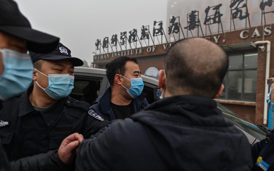 Security personnel are seen as members of the World Health Organization (WHO) team investigating the origins of the COVID-19 coronavirus, arrive at the Wuhan Institute of Virology in Wuhan, in China's central Hubei province on February 3, 2021 - HECTOR RETAMAL /AFP