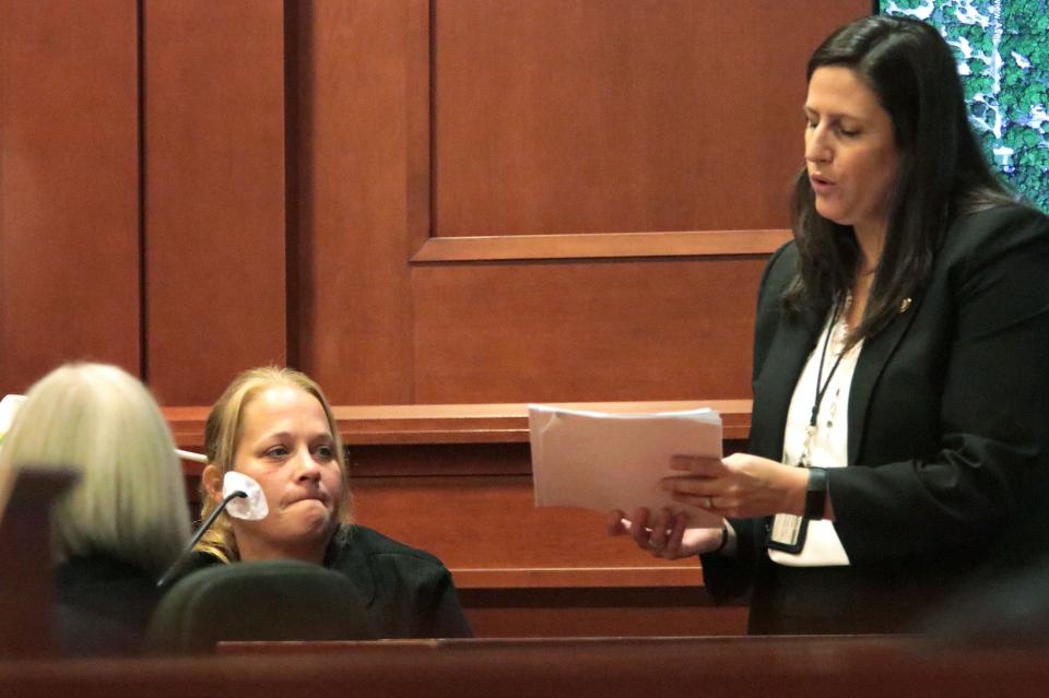 Danielle Pratt, mother of Justis Marie Garrett, bites her lip as she looks at text messages with prosecutor Megan Upchurch during Robert Kern's trial Wednesday, Aug. 3, 2022, in the Volusia County Courthouse in DeLand. He is accused of killing 16-year-old Justis in 2018.