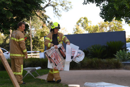 A fire fighter is seen carrying hazardous material bags into the South Korean consulate in Melbourne, Australia, January 9, 2019. AAP Image/James Ross via REUTERS