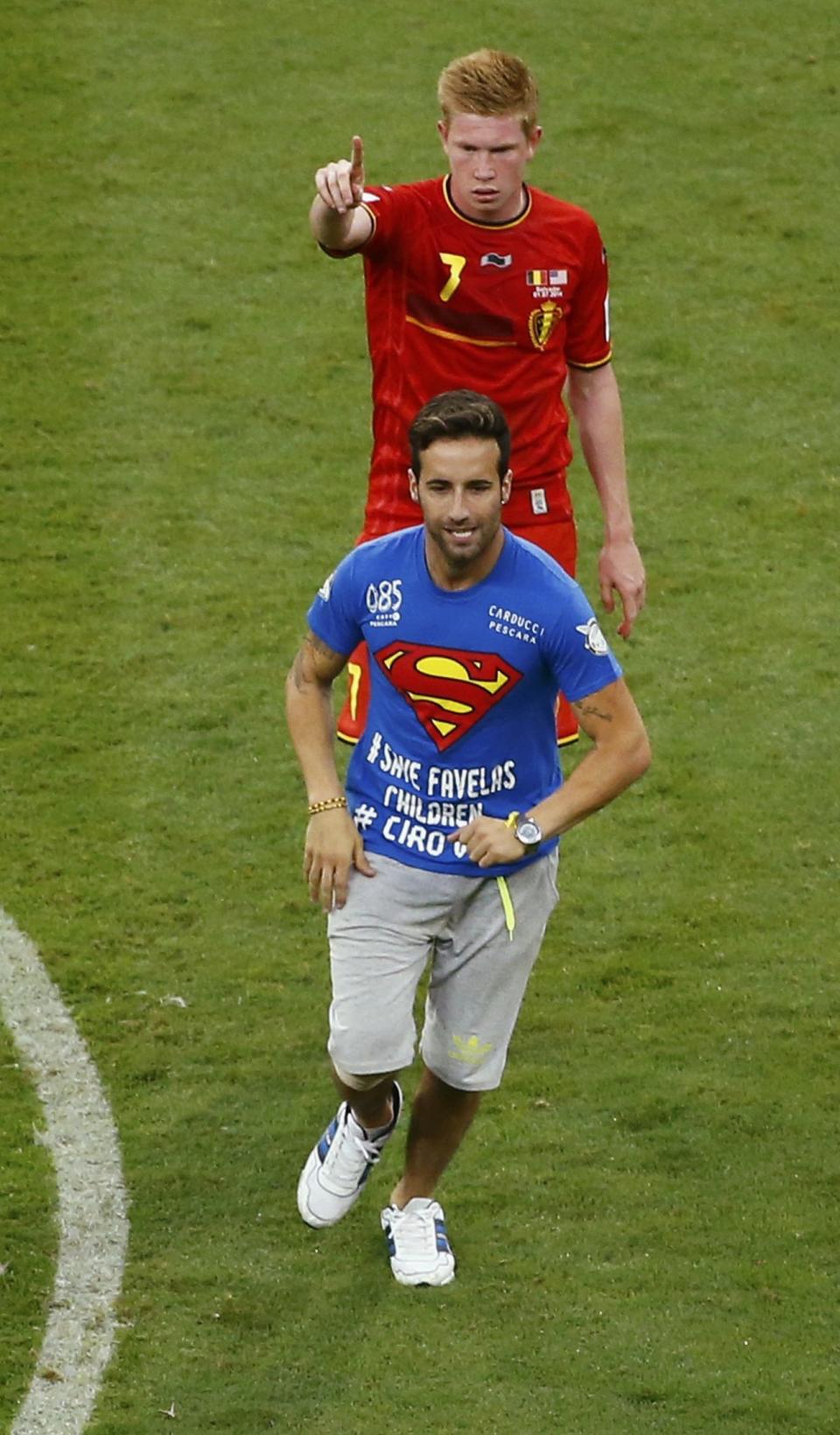 Belgium's Kevin De Bruyne gestures to a pitch invader to leave the field during their 2014 World Cup round of 16 game against the U.S. at the Fonte Nova arena in Salvador July 1, 2014. REUTERS/Ruben Sprich (BRAZIL - Tags: SOCCER SPORT WORLD CUP)