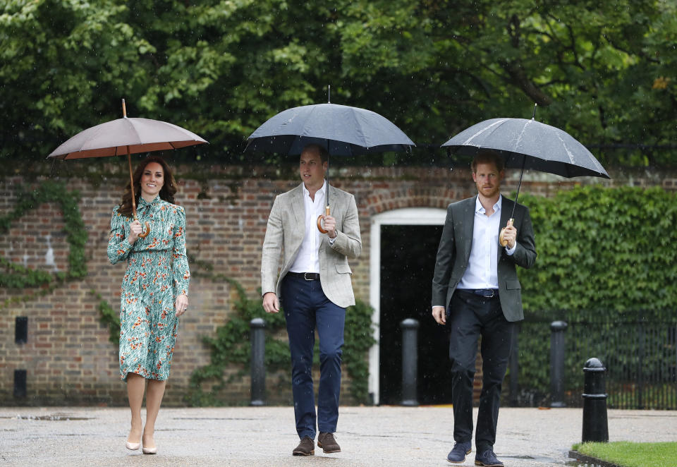 FILE - Britain's Prince William, center, his wife Kate, Duchess of Cambridge and Prince Harry arrive for an event at the memorial garden in Kensington Palace, London, Aug. 30, 2017. Prince Harry’s explosive memoir, with its damning allegations of a toxic relationship between the monarchy and the press, is likely to accelerate the pace of change already under way within the House of Windsor following the death of Queen Elizabeth II. (AP Photo/Kirsty Wigglesworth, File)