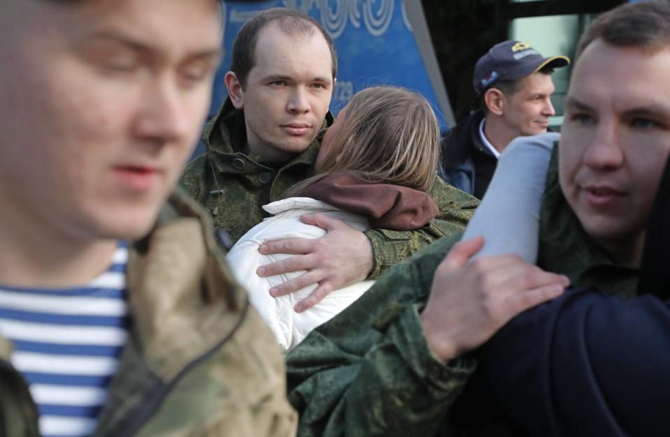 Russian conscripted men say goodbye to relatives at a recruiting office (EPA)