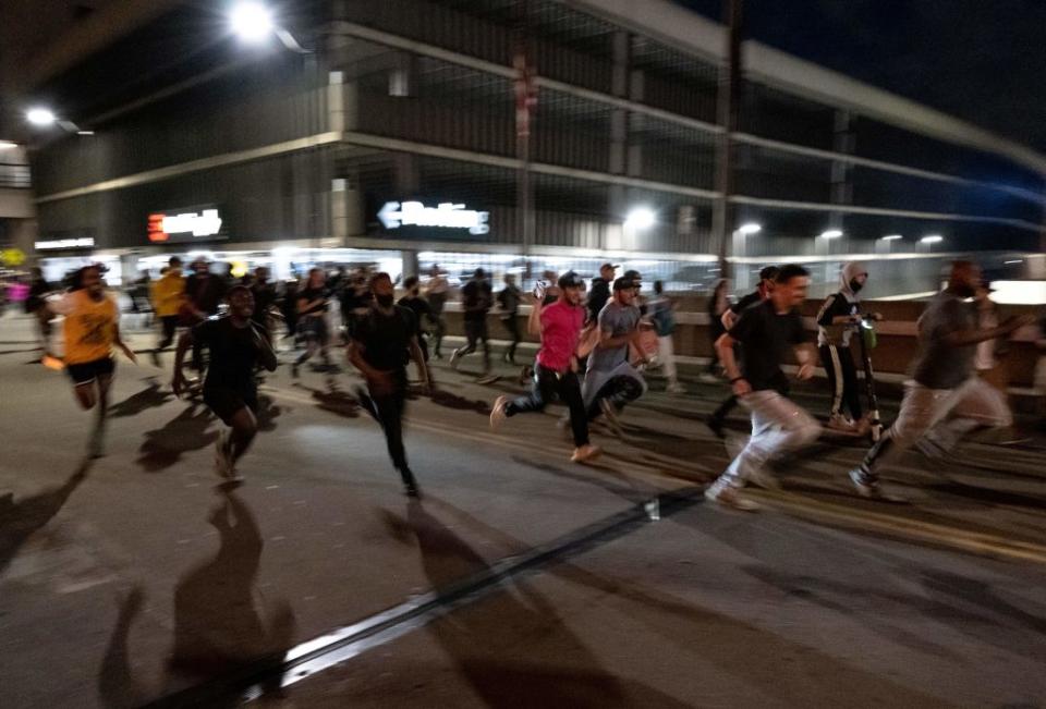 Demonstrators run from the police during a protest in the city of Detroit, Michigan, on May 29, 2020, over the death of George Floyd, a black man who died after a white policeman knelt on his neck for several minutes.