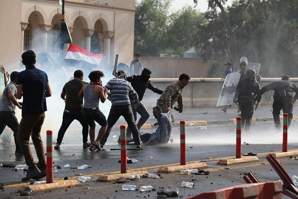 Iraq security forces arrest a protester during a protest in Tahrir Square, in central Baghdad, Iraq, Tuesday, Oct. 1, 2019. Iraqi security forces fired tear gas on hundreds of protesters in the Iraqi capital who were demonstrating against corruption and bad public services. (AP Photo/Khalid Mohammed)