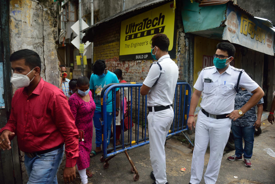 People move in and out of the containment area before the lockdown.Coronavirus has affected a huge number of people in Kolkata daily, so to curb the spread of coronavirus pandemic the government has identified some areas with high number of cases and imposed complete lockdown for 7 days in this selected containment areas in Kolkata where no one can go out or go in Police personnel will provide essential items to the residents. (Photo by Sumit Sanyal/SOPA Images/LightRocket via Getty Images)