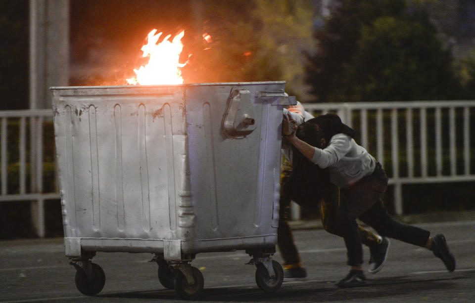 Image: Protesters push a burning trash can towards riot police during a rally against the results of a parliamentary vote in Bishkek, Kyrgyzstan (Vladimir Voronin / AP)