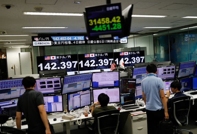 Employees of the foreign exchange trading company Gaitame.com work in front of monitors displaying the Japanese yen exchange rate against the U.S. dollar, in Tokyo