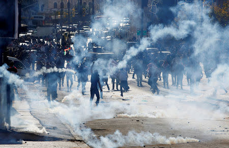FILE PHOTO: Palestinian demonstrators react to tear gas fired by Israeli troops during clashes at a protest against U.S. President Donald Trump's decision to recognize Jerusalem as the capital of Israel, in the West Bank city of Bethlehem December 9, 2017. REUTERS/Mussa Qawasma/File Photo