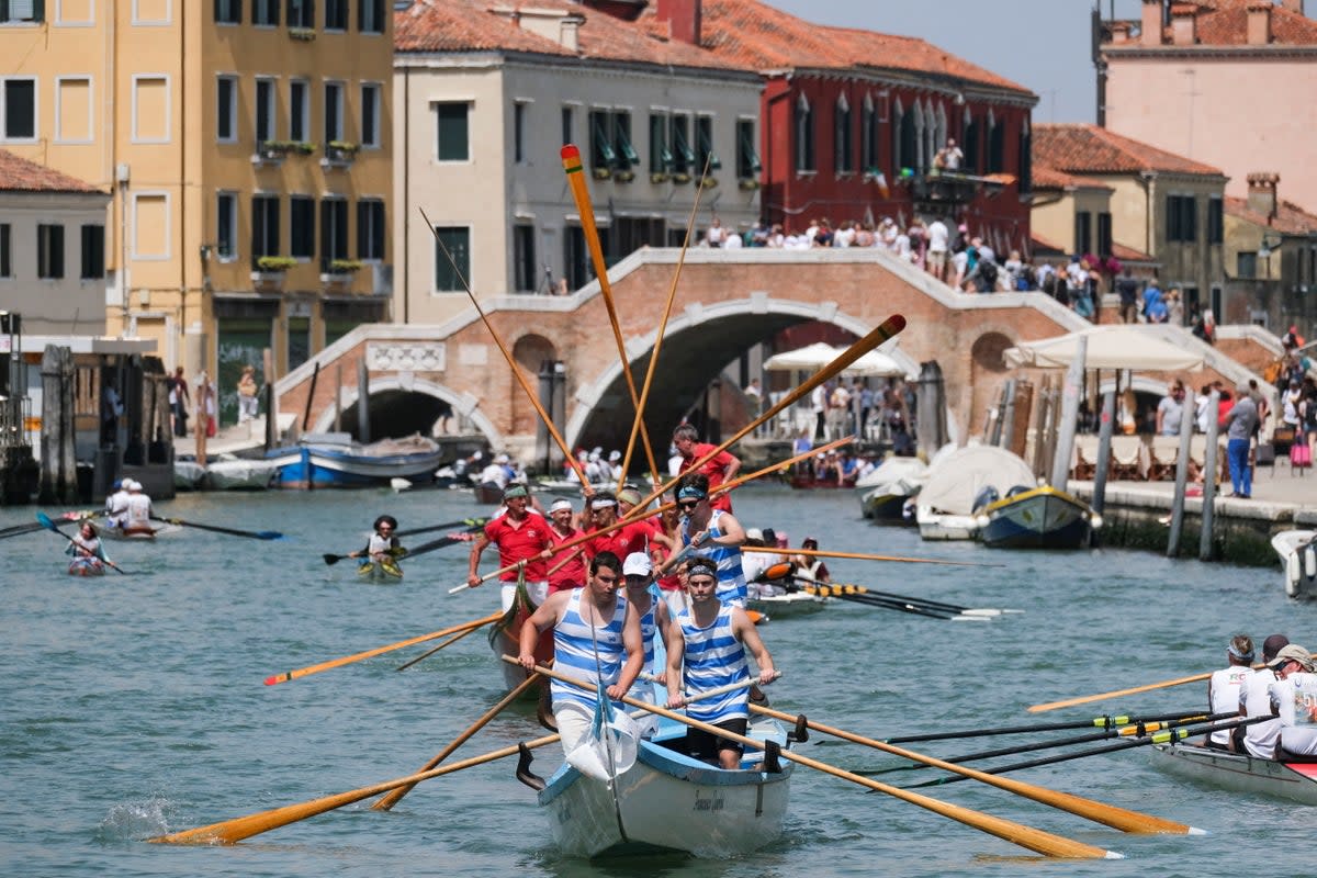 Rowers arrive at the Cannaregio Canal as part of the Vogalonga regatta in Venice (Reuters)