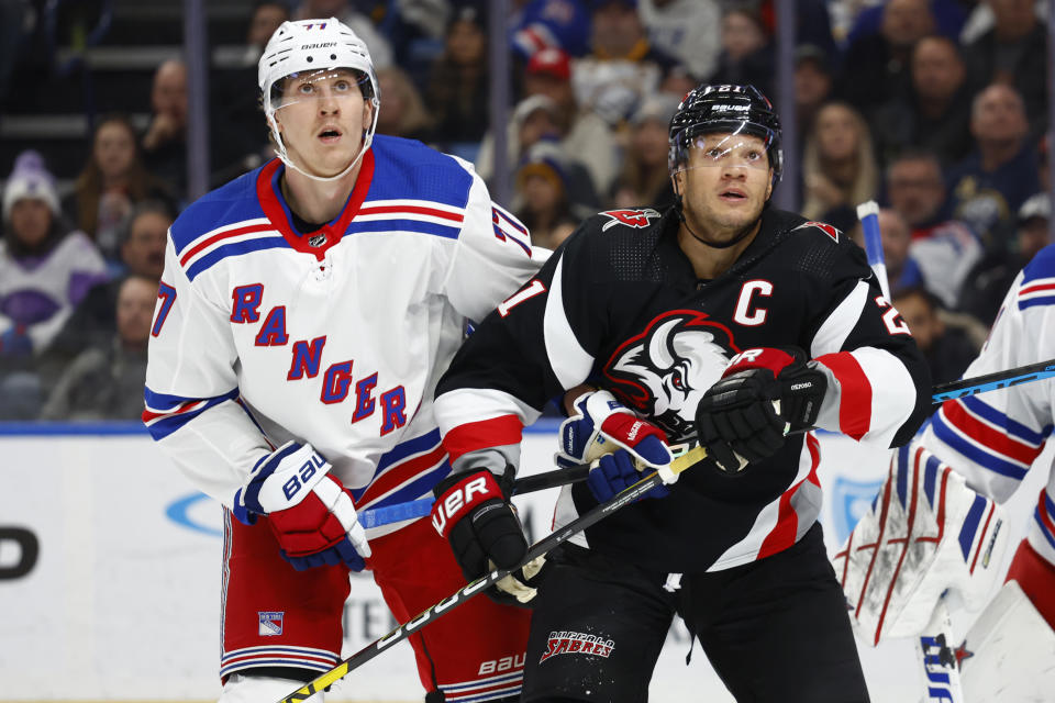 New York Rangers defenseman Niko Mikkola (77) and Buffalo Sabres right wing Kyle Okposo (21) watch the puck go out of play during the first period of an NHL hockey game, Saturday, March 11, 2023, in Buffalo, N.Y. (AP Photo/Jeffrey T. Barnes)