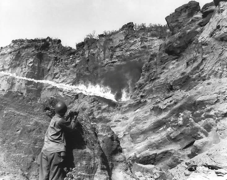 A flame thrower in use against Japanese forces holding out in caves along Iwo Jima's coastal cliffs