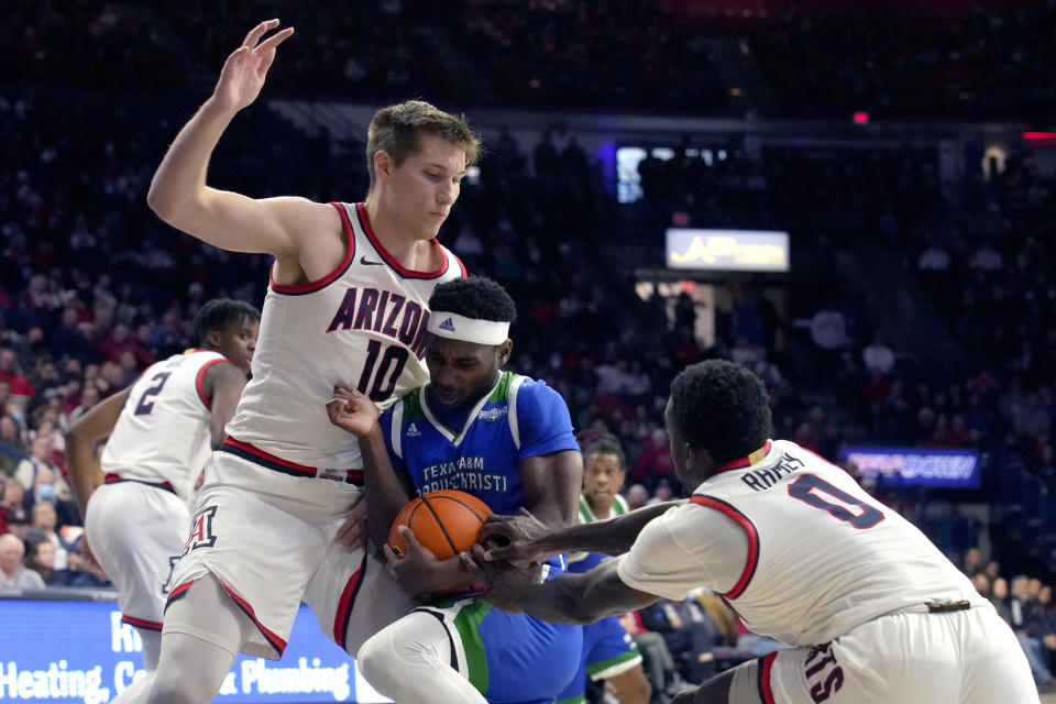 Texas A&M Corpus Christi guard Jalen Jackson (4) drives between Arizona forward Azuolas Tubelis (10) and guard Courtney Ramey (0) during the first half of an NCAA college basketball game, Tuesday, Dec. 13, 2022, in Tucson, Ariz. (AP Photo/Rick Scuteri)