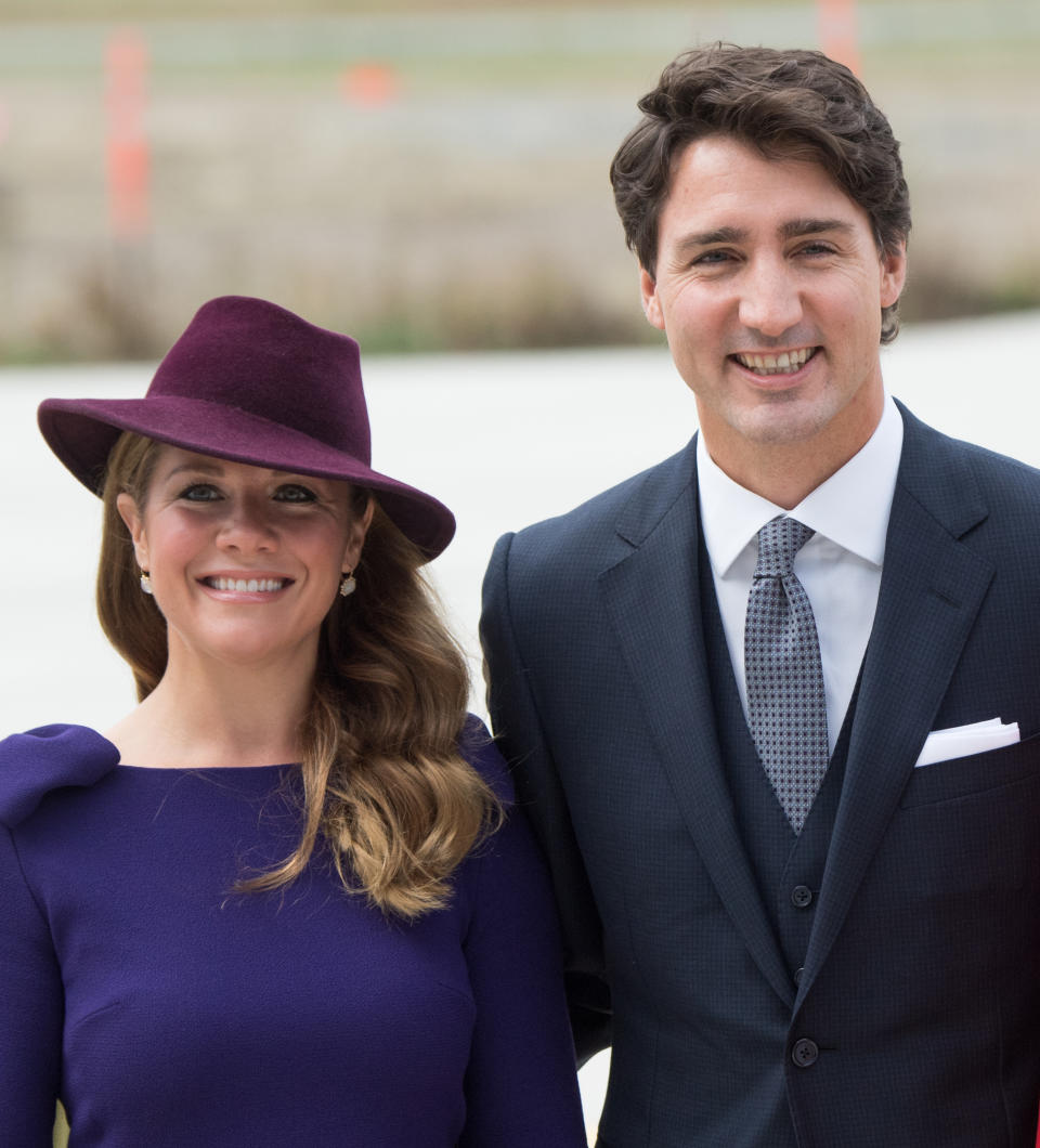 Sophie Grégoire Trudeau wearing purple dress and hat next to ex-husband Justin Trudeau. (Image via Getty Images)