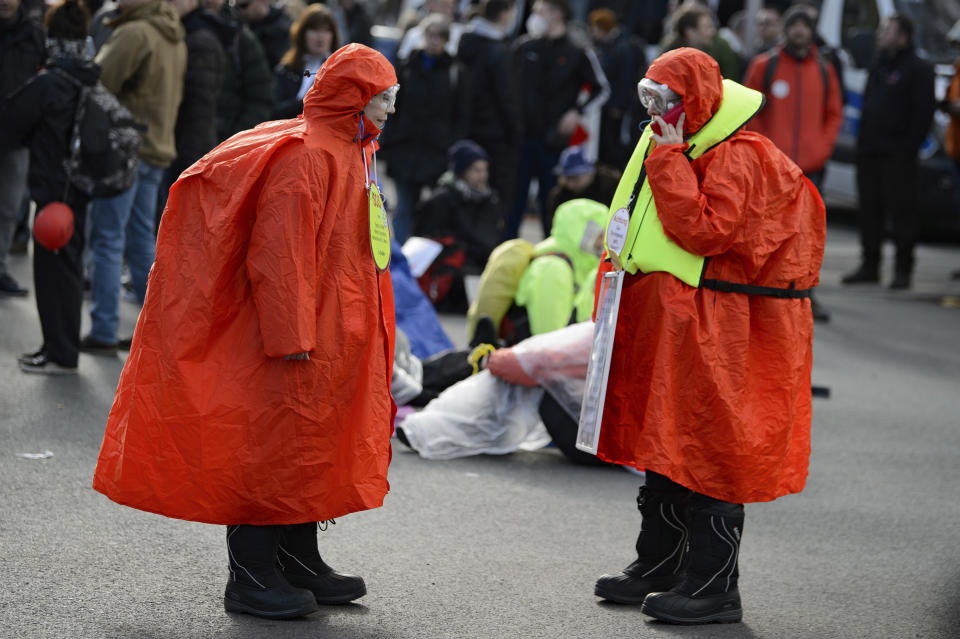 Participants wearing red coats stand in the street during a rally under the slogan "Free Citizens Kassel - Basic Rights and Democracy" in Kassel, Germany, Saturday, March 20, 2021. (Swen Pfoertner/dpa via AP)