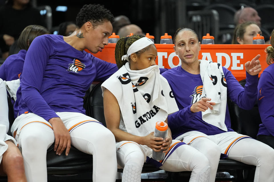 Phoenix Mercury center Brittney Griner, left, talks with Phoenix Mercury guard Diana Taurasi, right, on the bench during the first half of a WNBA preseason basketball game against the Los Angeles Sparks, Friday, May 12, 2023, in Phoenix. (AP Photo/Matt York)