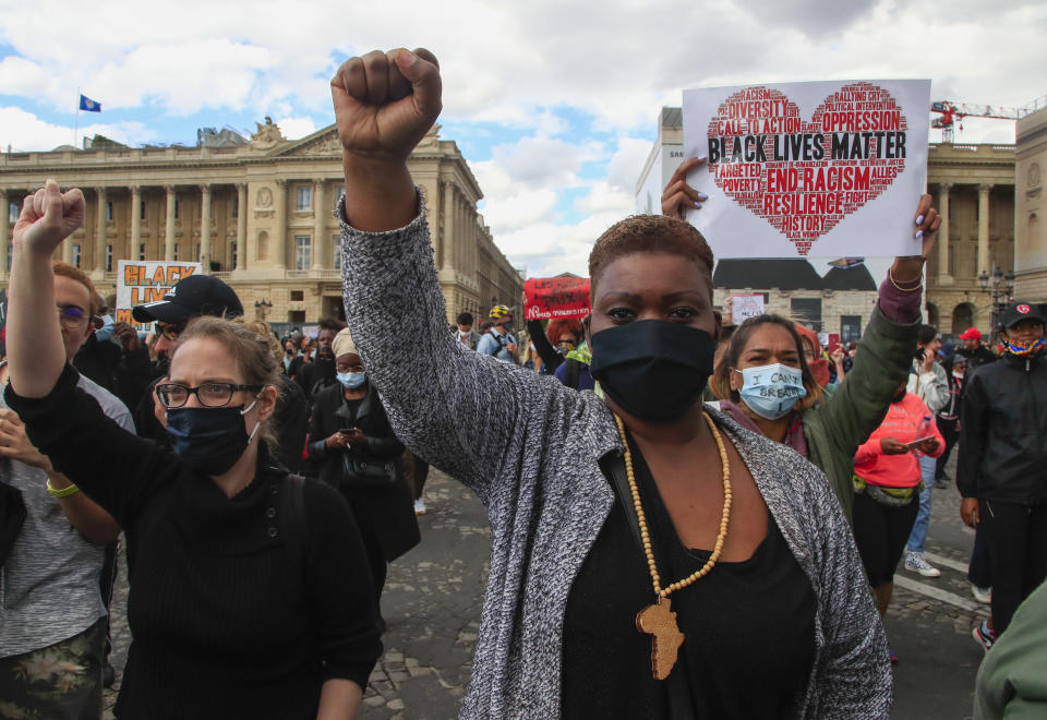 Demonstrators clench fists in Paris, France, Saturday, June 6, 2020, to protest against the recent killing of George Floyd, a black man who died in police custody in Minneapolis, U.S.A., after being restrained by police officers on May 25, 2020. Further protests are planned over the weekend in European cities, some defying restrictions imposed by authorities because of the coronavirus pandemic. (AP Photo/Michel Euler)