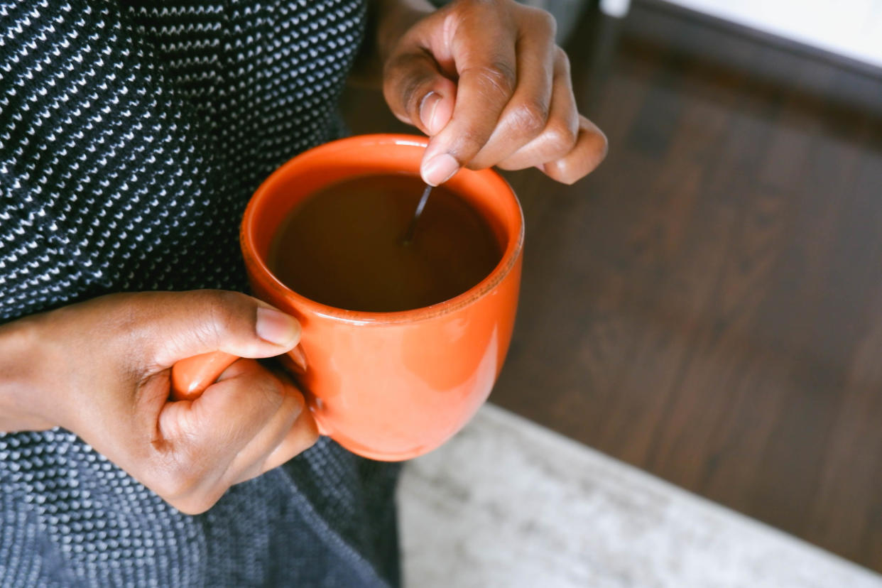 A woman stirring a cup of coffee