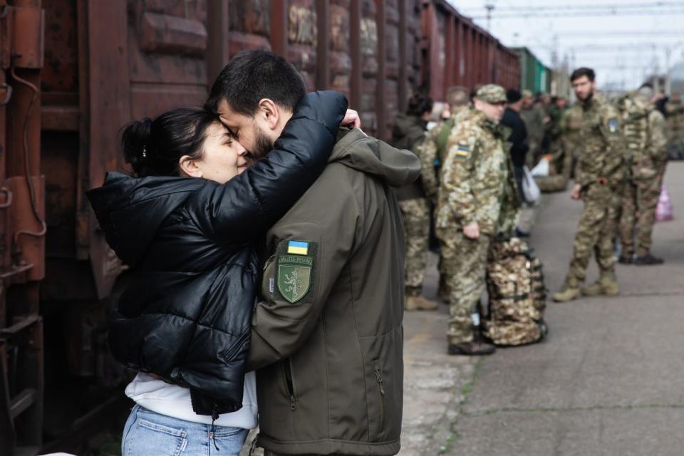 A soldier of the Ukrainian Armed Forces embraces his partner at a train station in Kramatorsk, Donetsk Oblast, on April 9, 2023. The railway station in Kramatorsk has already become a regular meeting place for Ukrainian soldiers and their loved ones. Despite the continuous shelling in the east of Ukraine and beyond, soldiers often find a few days, or even hours, to see their families and/or friends, meeting at the train station in Kramatorsk. (Mykhaylo Palinchak/SOPA Images/LightRocket via Getty Images)