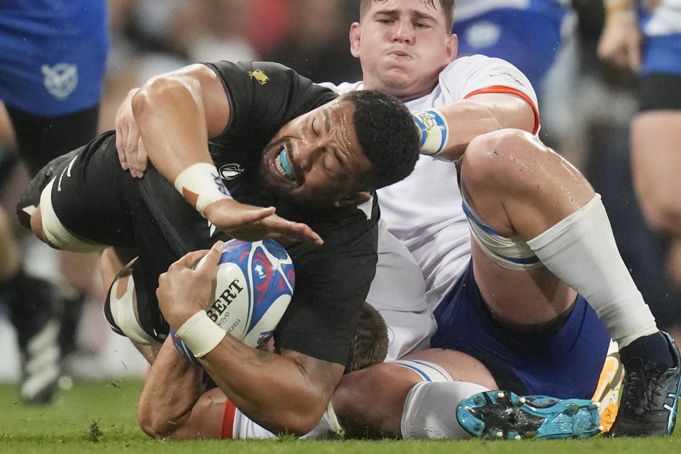 New Zealand's Ardie Savea, left, challenges during the Rugby World Cup Pool A match between New Zealand and Namibia at the Stadium de Toulouse in Toulouse, France, Friday, Sept. 15, 2023. (AP Photo/Christophe Ena)