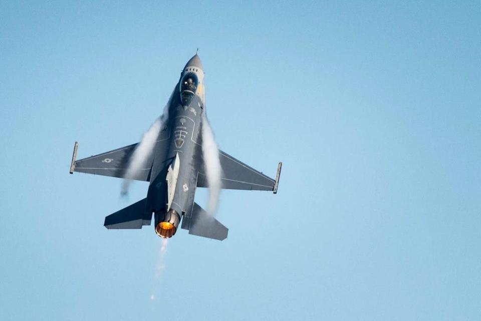 a fighter jet is surrounded by a condensed cloud as it breaks the sound barrier